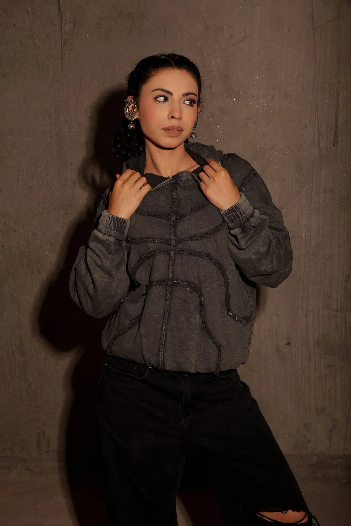Woman wearing a gray textured jacket against a brown background
