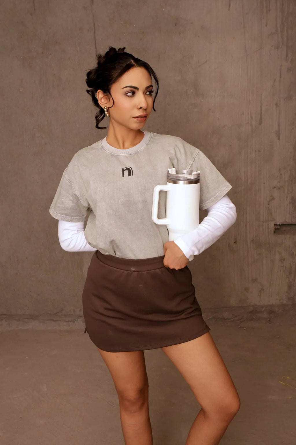 Woman holding a white mug against a plain background